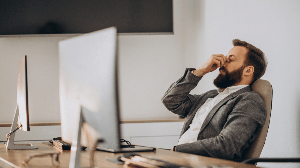 Businessman working at his desk, reflecting on ways to improve work-life balance.